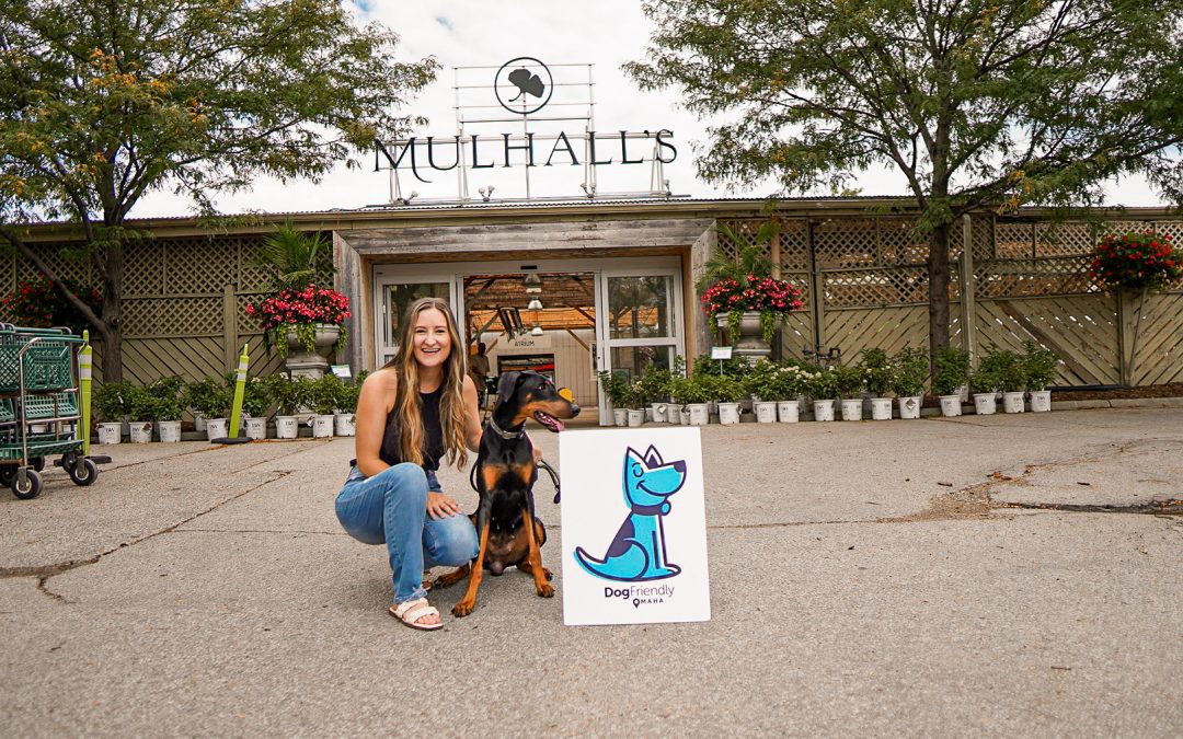 woman and her dog with the dog friendly omaha sign outside mulhall's